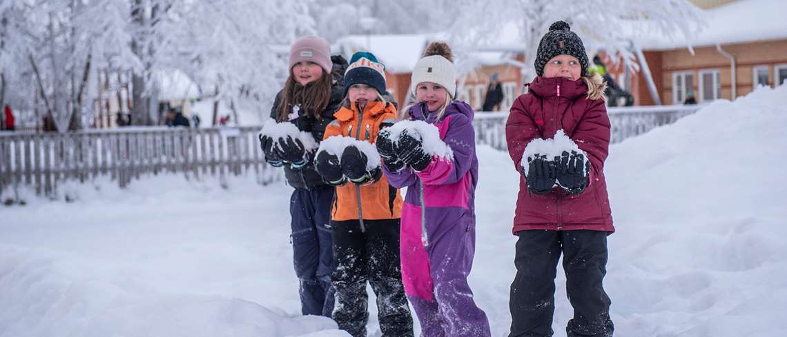 Flickor med stora snöbollar i famnen - lågstadieelever har rast utanför Smedskolan.