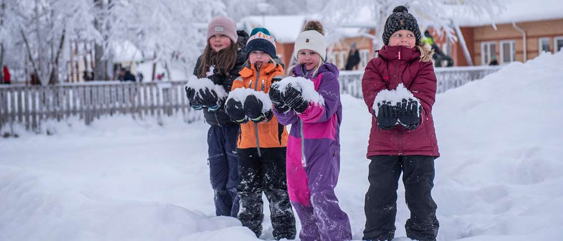 Flickor med stora snöbollar i famnen - lågstadieelever har rast utanför Smedskolan.