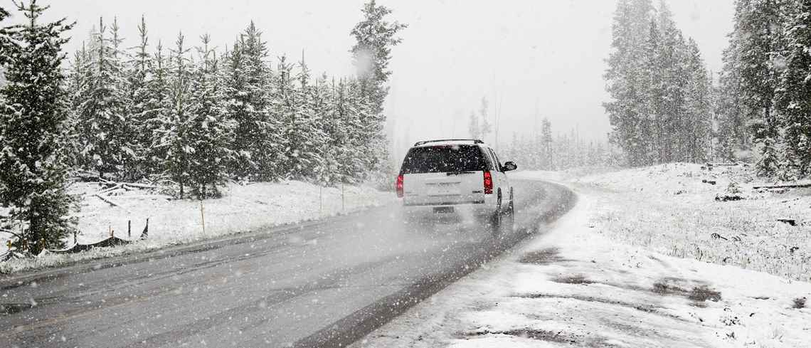 Bil som kör på vinterväg med snöslask och nederbörd