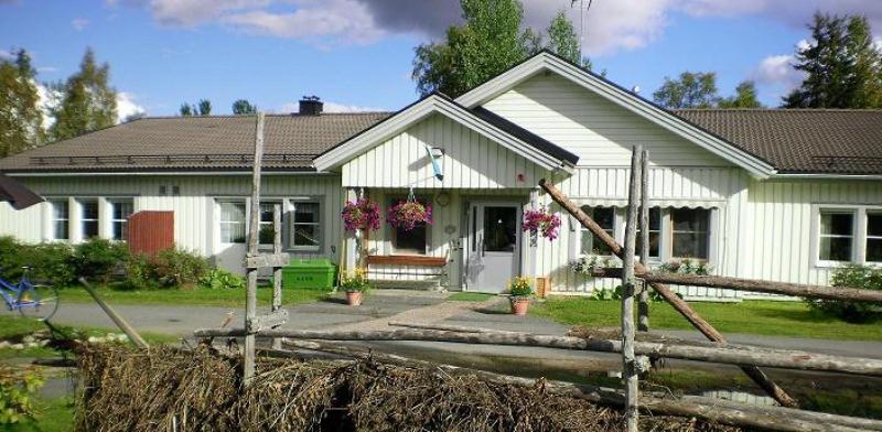 Asphemmets äldreboende, tagen sommartid utomhus. Höhässja, blommor och buskar framför ingången.