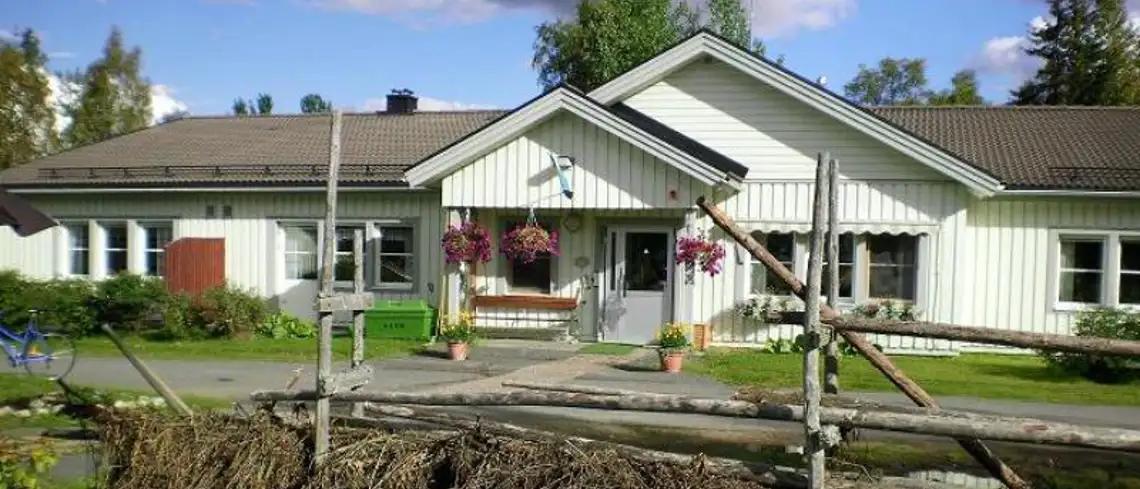 Asphemmets äldreboende, tagen sommartid utomhus. Höhässja, blommor och buskar framför ingången.
