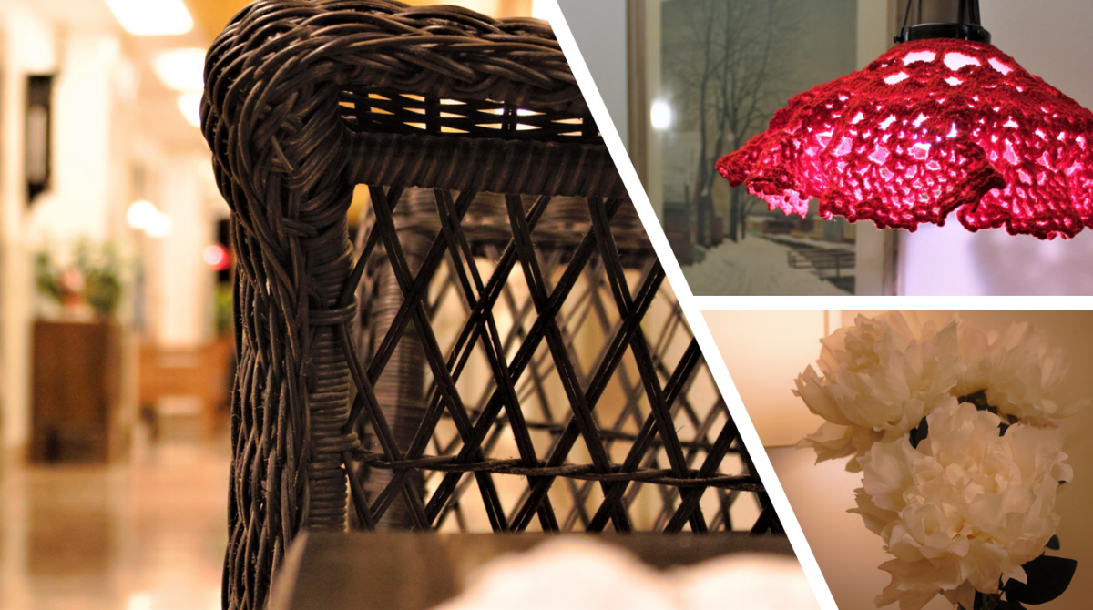 På bilden finns rottingstol, blommor och en lampa med virkad röd skärm över skomakarlampan.