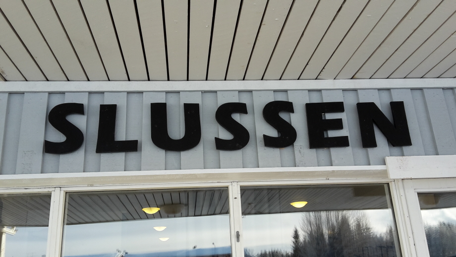 Bild på skylten Slussen, tagen utanför lokalen.